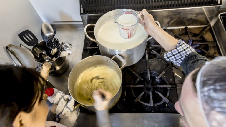 Pouring milk to make bechamel for white lasagne